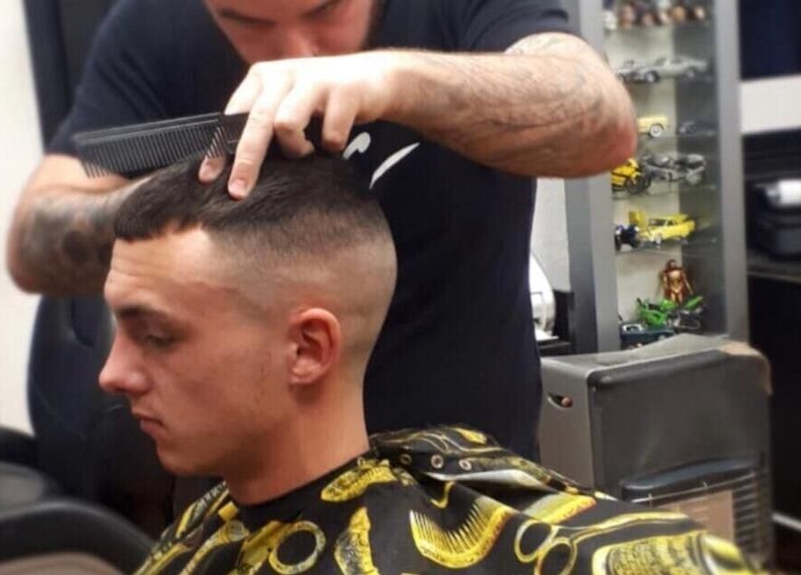 Barber styling a haircut at Paul's Hairdressing for Men, Wallsend, England, GB.