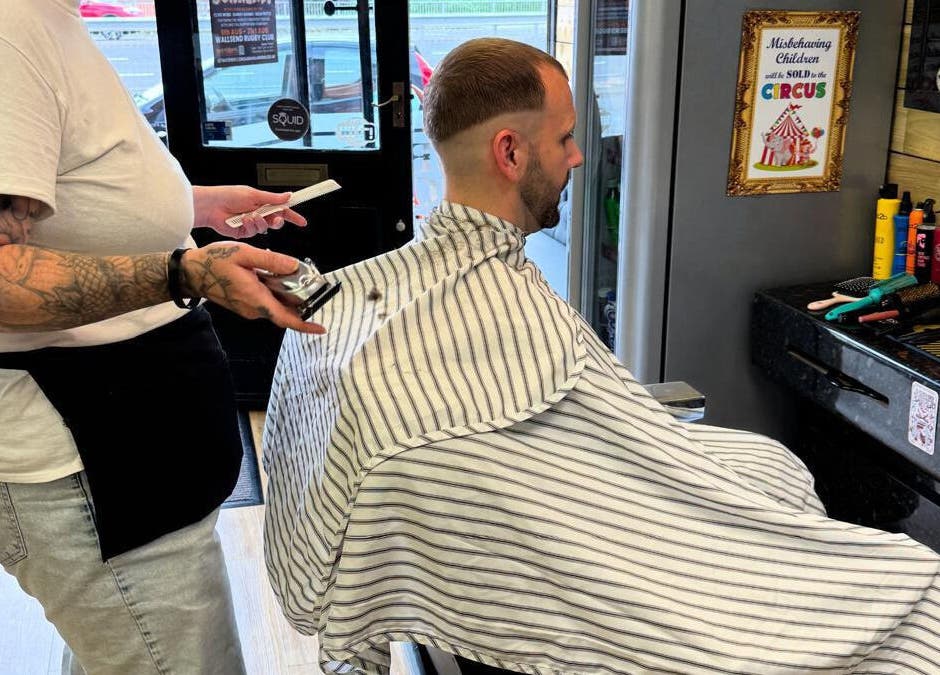 Barber at Paul's Hairdressing for Men in Wallsend, England, GB giving a modern haircut to a client.