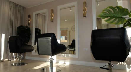 Elegant salon interior at Hair.byizzyangellx in Totton, England, GB with stylish chairs and mirrors.