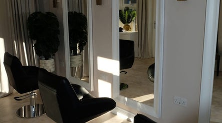 Elegant salon interior at Hair.byizzyangellx, Totton, England with stylish black chairs and mirrors.