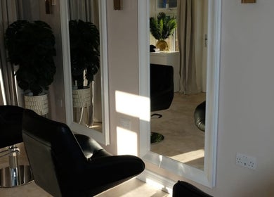 Stylish salon interior at Hair Byizzyangellx in Totton, England, GB, featuring modern chairs and large mirrors.