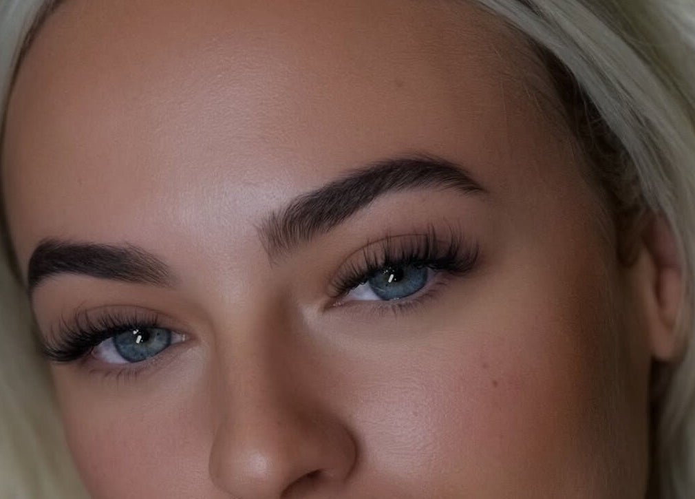 Close-up of expertly shaped eyebrows and vibrant eyes at Kiah Lopez Beauty in Gibraltar, GI.