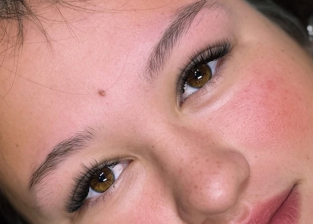 Close-up of a smiling person with flawless skin at Kiah Lopez Beauty, Gibraltar, GI.