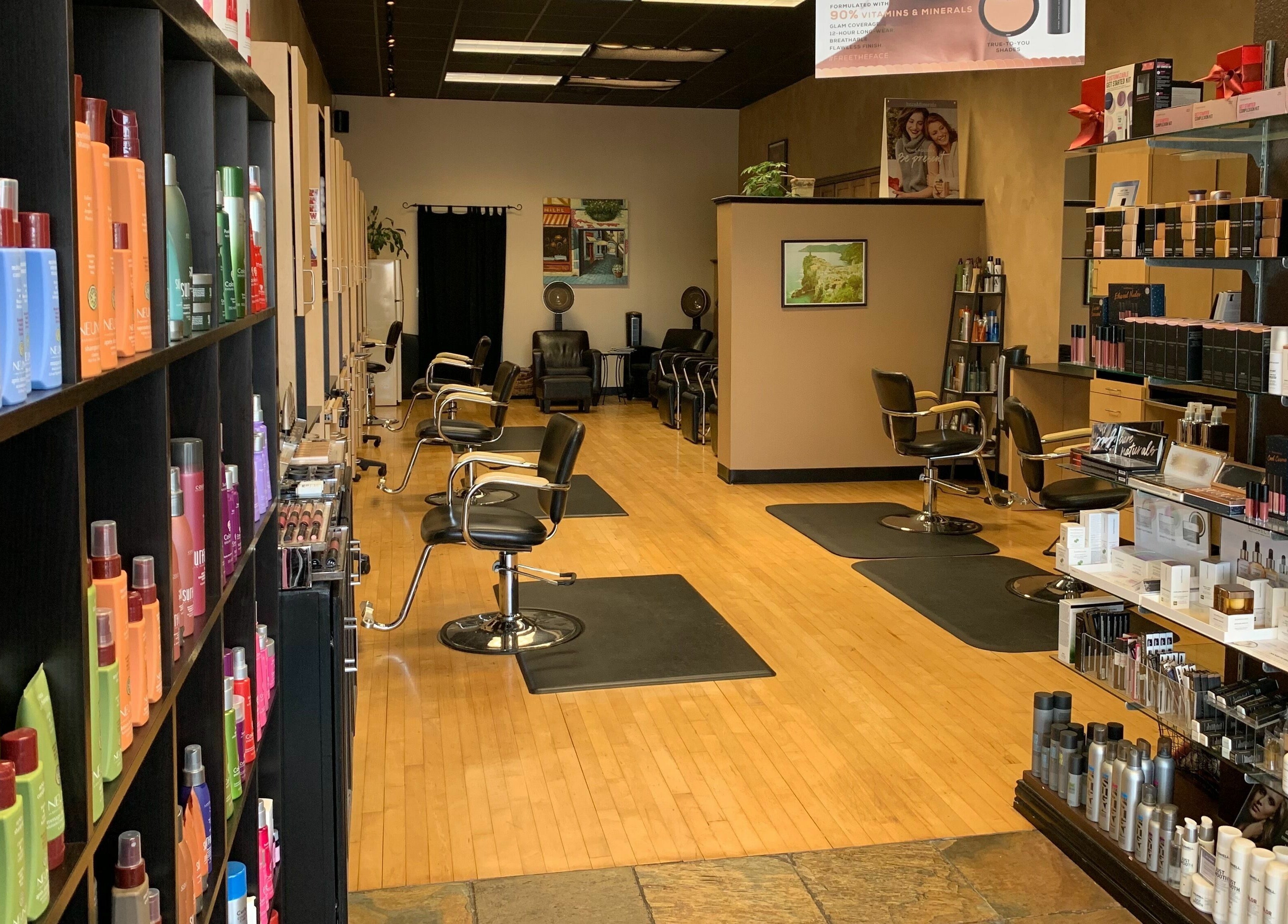 Interior view of Salone Di Essenza in Austin, Texas, US with stylish salon chairs and beauty products displayed.