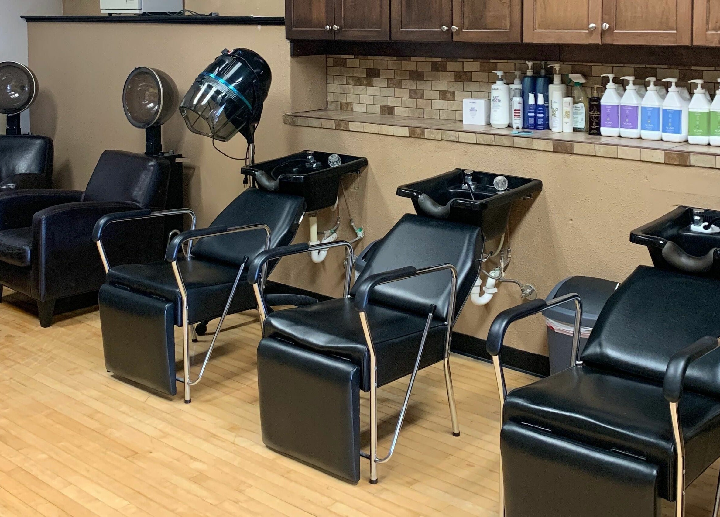 Modern hair washing stations at Salone Di Essenza in Austin, Texas, US with black chairs and cabinets.