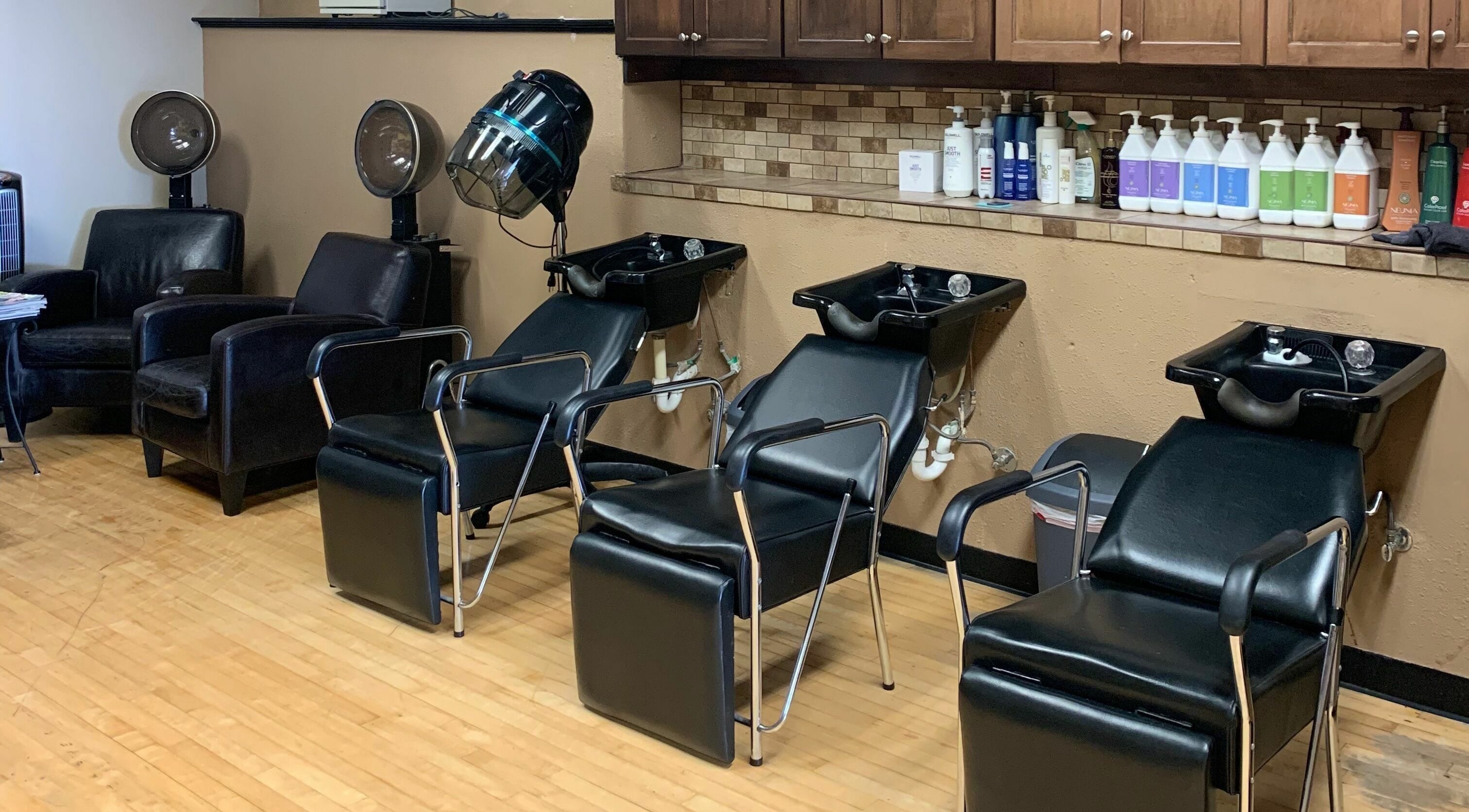 Modern hair washing stations at Salone Di Essenza in Austin, Texas, US with black chairs and cabinets.