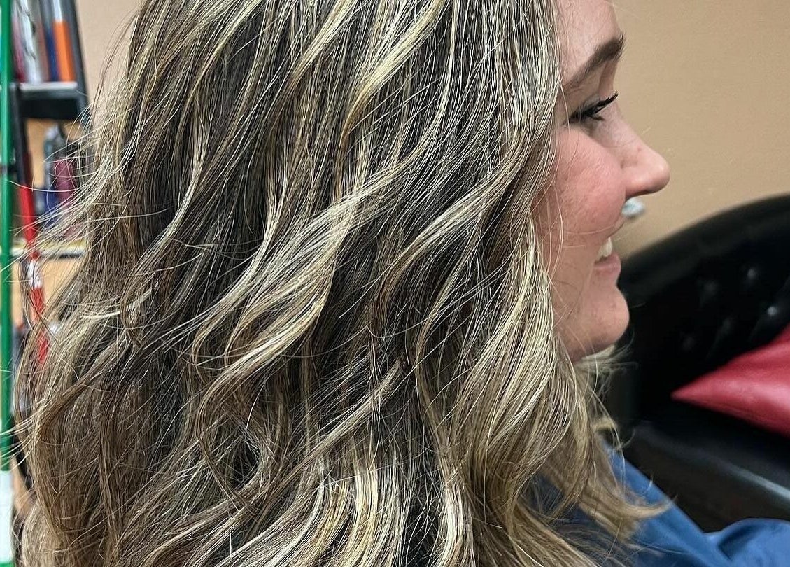 Beautiful wavy blonde hair styled at Salone Di Essenza, Austin, Texas, US, showcasing modern hair trends.