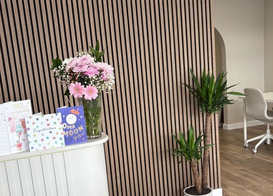 Chic reception area at Miceli Beauty Studio, Waterlooville, England, with flowers and a modern desk.