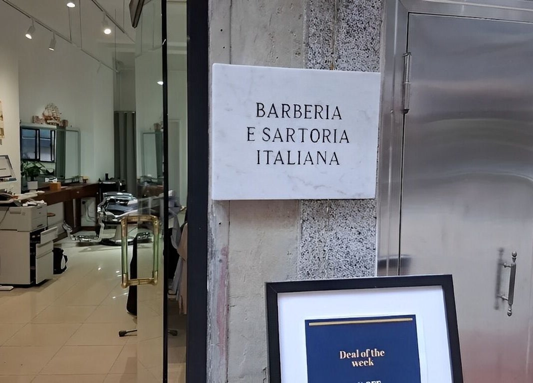 Entrance of Barberia e Sartoria Italiana on Hong Kong Island showcasing chic interior.