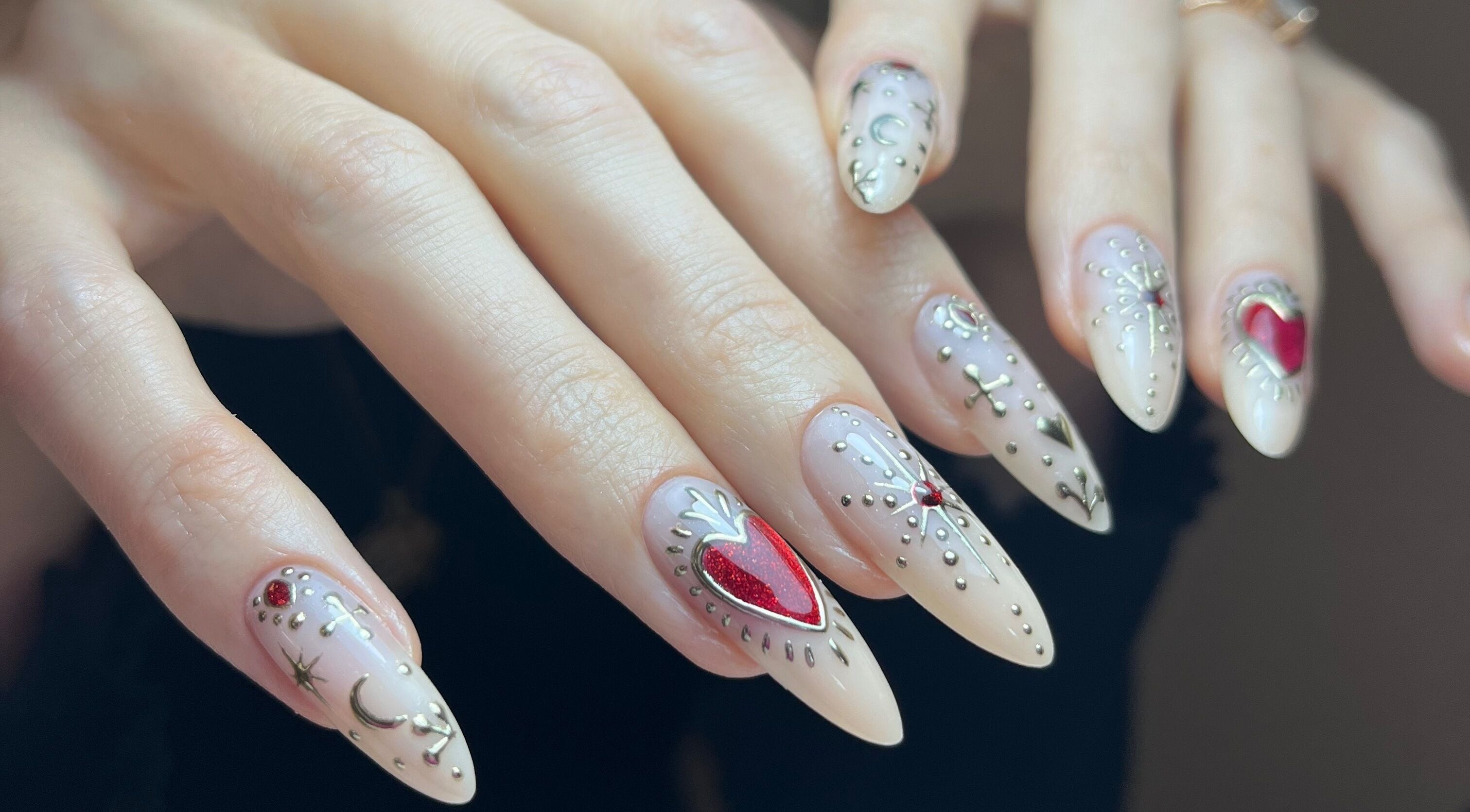 Intricate nail art from Claws By Clayre in Glasgow, Scotland, GB showcasing detailed heart and moon designs.