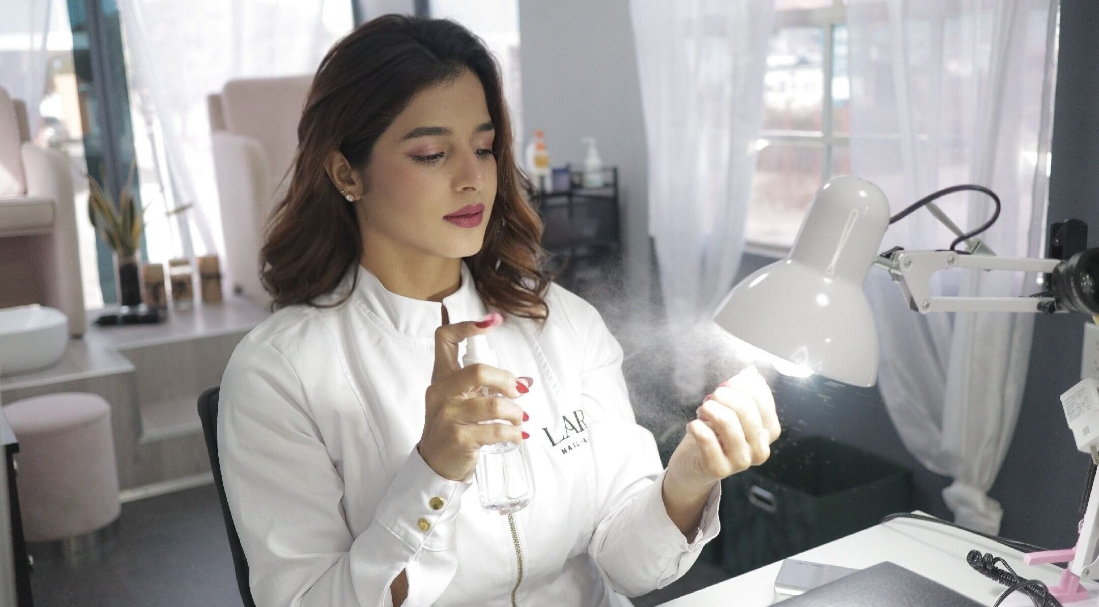 Técnica rociando producto en Lara beauty studio, Willemstad, Curaçao, CW.