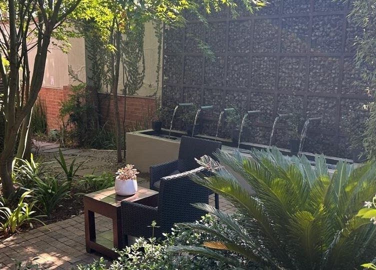 Tranquil garden oasis at Faithful Aesthetics, Pretoria, Gauteng, ZA with lush greenery and seating.