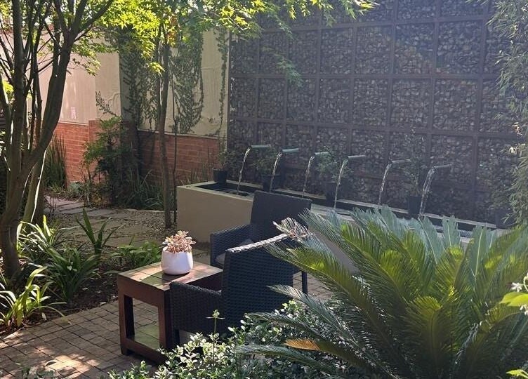 Tranquil garden oasis at Faithful Aesthetics, Pretoria, Gauteng, ZA with lush greenery and seating.