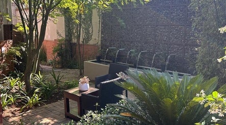 Tranquil garden oasis at Faithful Aesthetics, Pretoria, Gauteng, ZA with lush greenery and seating.