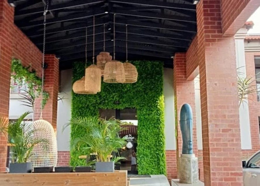 Lush entrance at Faithful Aesthetics, Pretoria, Gauteng, ZA with greenery and wicker lanterns.