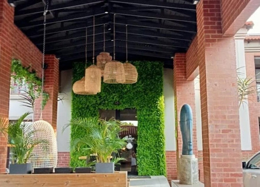 Lush entrance at Faithful Aesthetics, Pretoria, Gauteng, ZA with greenery and wicker lanterns.