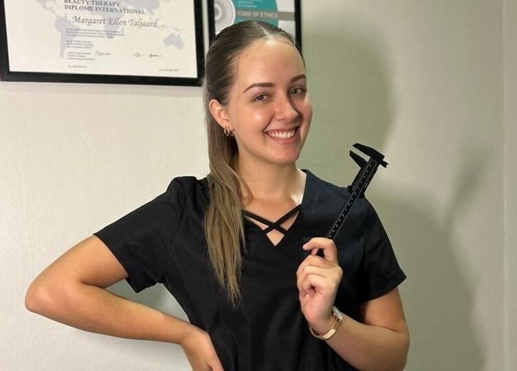 Smiling professional at Faithful Aesthetics, Pretoria, Gauteng, ZA holding a measuring tool.