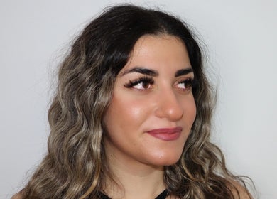 Femme aux cheveux ondulés et maquillage soigné chez Salon Eye’m Back, Laval, Québec, CA.
