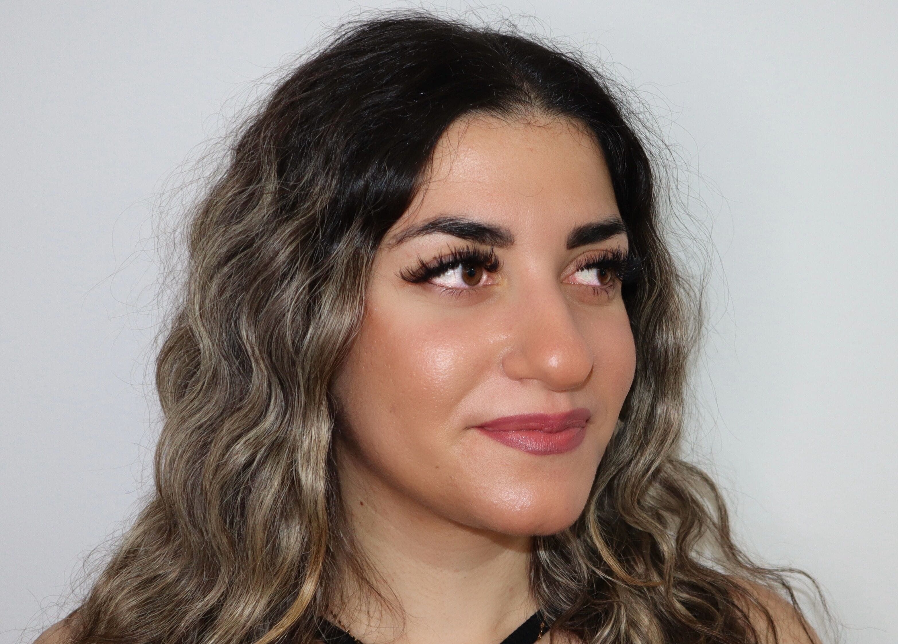 Femme aux cheveux ondulés et maquillage soigné chez Salon Eye’m Back, Laval, Québec, CA.