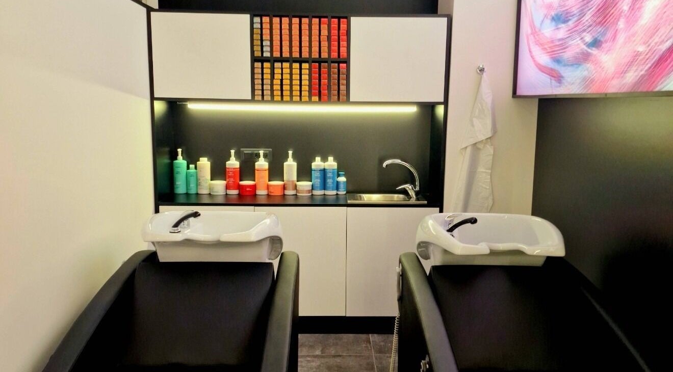 Lavelli moderni in salone HairPro.Tv, Bellizzi, Campania, IT con scaffali di prodotti colorati.