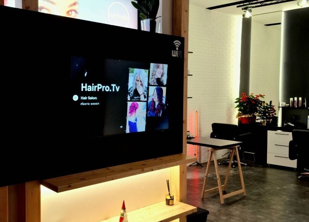 Interno moderno del salone HairPro.Tv a Bellizzi, Campania, IT con postazioni eleganti e piante decorative.