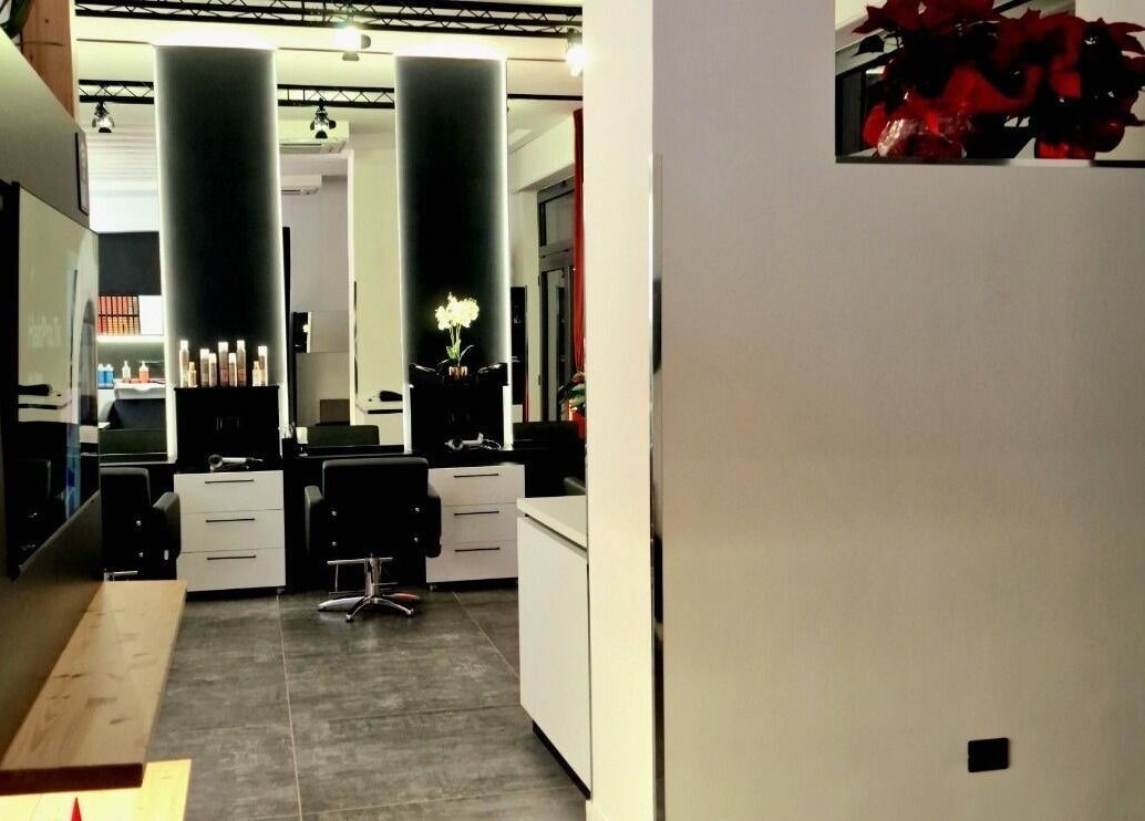 Interno moderno di HairPro.Tv a Bellizzi, Campania, IT con sedie eleganti e illuminazione sofisticata.