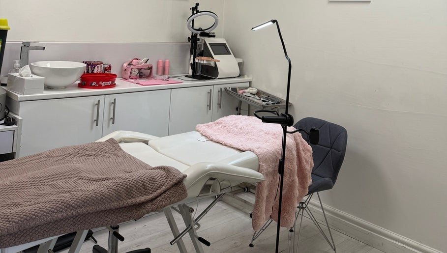 Treatment room at Rosa Aesthetics Apsley, Hemel Hempstead, featuring a cozy recliner and modern equipment.
