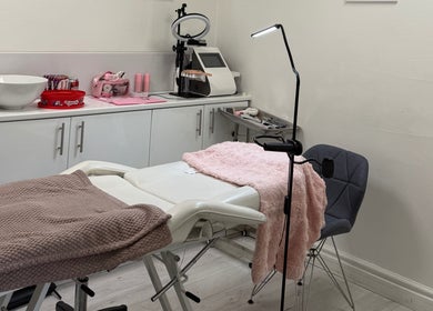 Treatment room at Rosa Aesthetics Apsley, Hemel Hempstead, featuring a cozy recliner and modern equipment.
