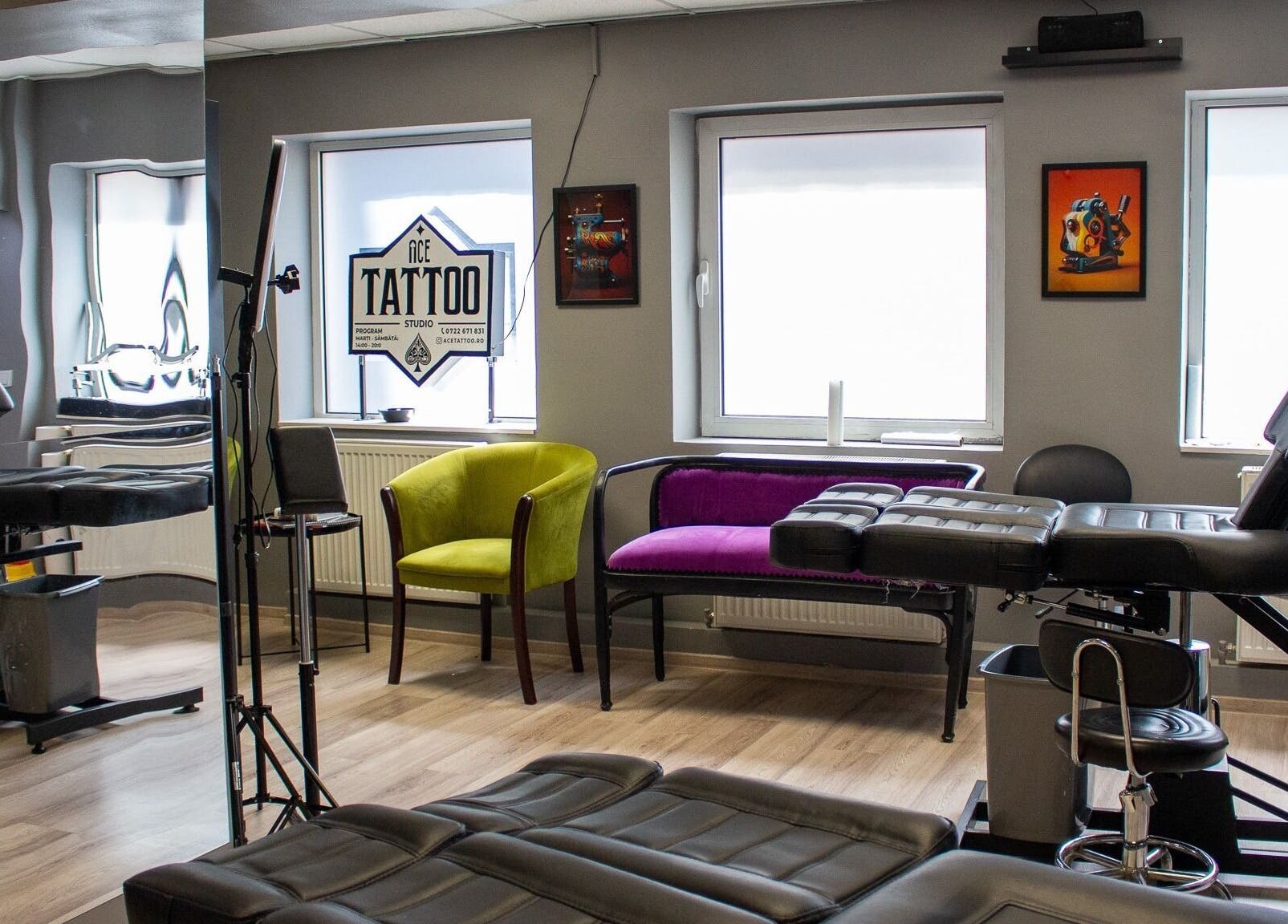 Interior modern al Ace Tattoo Parlour din București, București, RO, cu scaune confortabile și artă pe pereți.