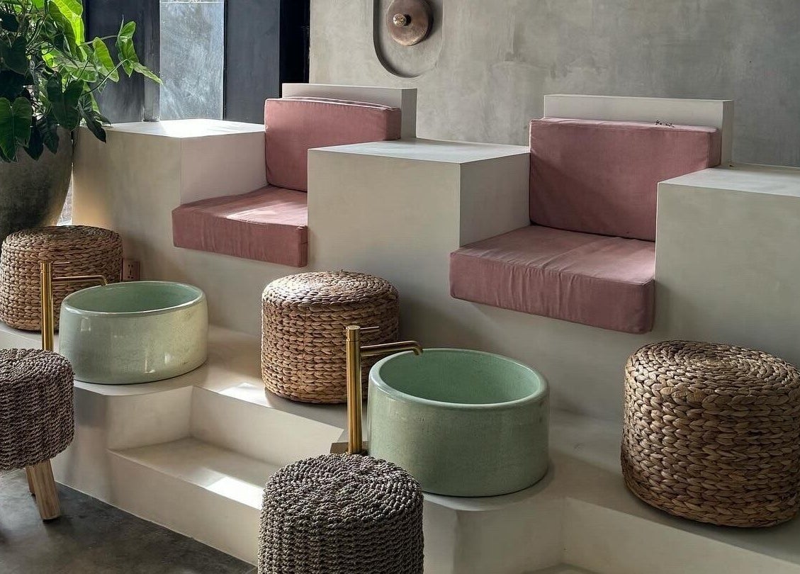Relaxing spa seating at The Rustic Sun - Berawa, Bali, Bali, ID with woven stools and green foot baths.