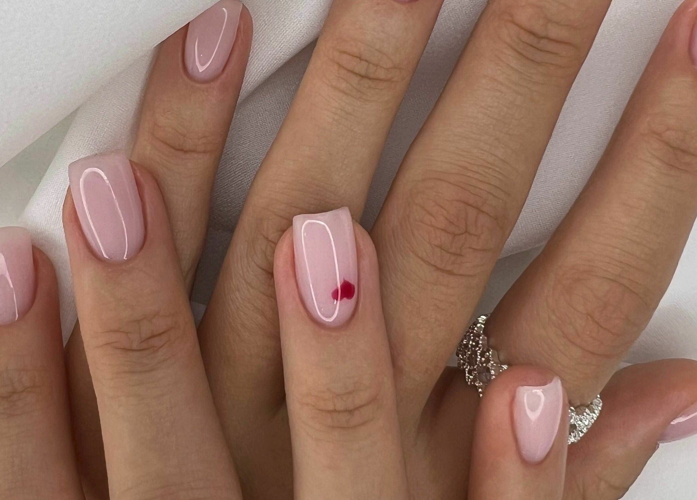 Elegant pink manicure with heart detail at Beauty Stories Dmcc, Dubai, Dubai, AE.