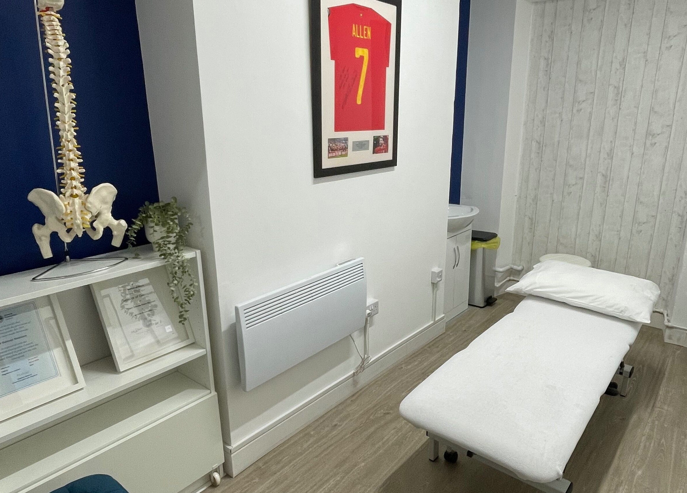 Treatment room at OsteoHub Mumbles, Swansea, Wales, GB with a massage table and decor details.