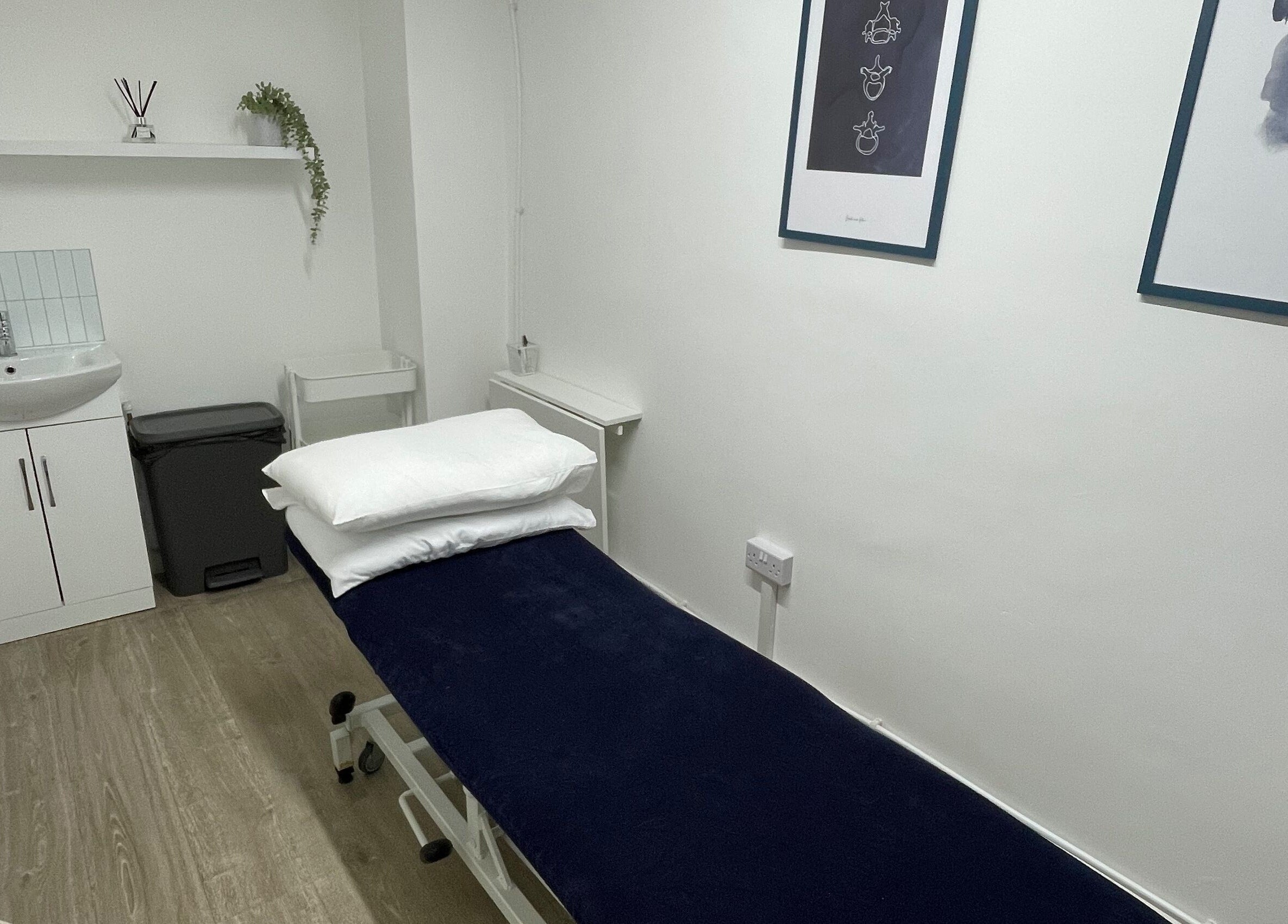 Elegant treatment room at OsteoHub Mumbles in Swansea, Wales, GB, featuring a plush bed and calming decor.