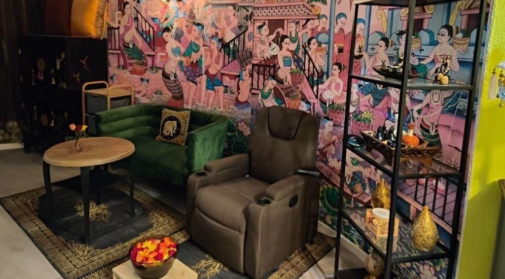 Innenraum von Pimpiman Thai Spa in Bern, Bern, CH mit thailändischen Wandbildern und gemütlichem Sitzbereich.