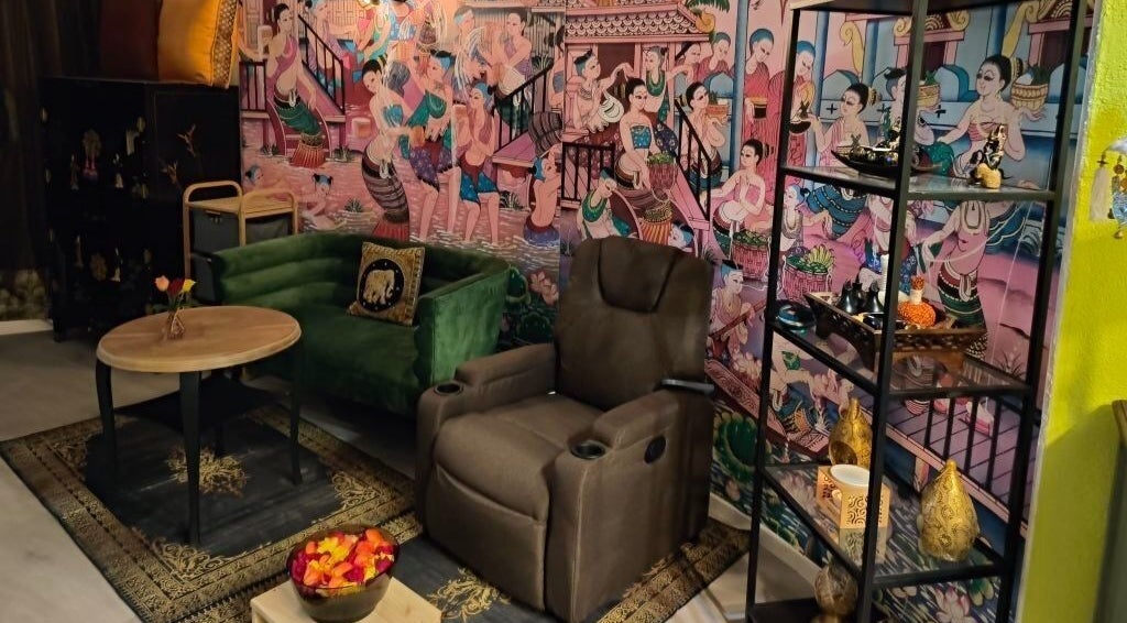 Innenraum von Pimpiman Thai Spa in Bern, Bern, CH mit thailändischen Wandbildern und gemütlichem Sitzbereich.