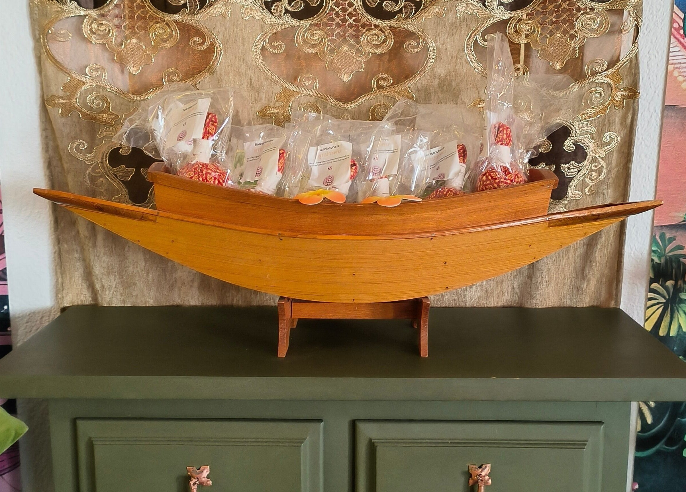 Pimpiman Thai Spa, Bern: Bootsdarstellung mit Pflegeprodukten auf grünem Tisch.