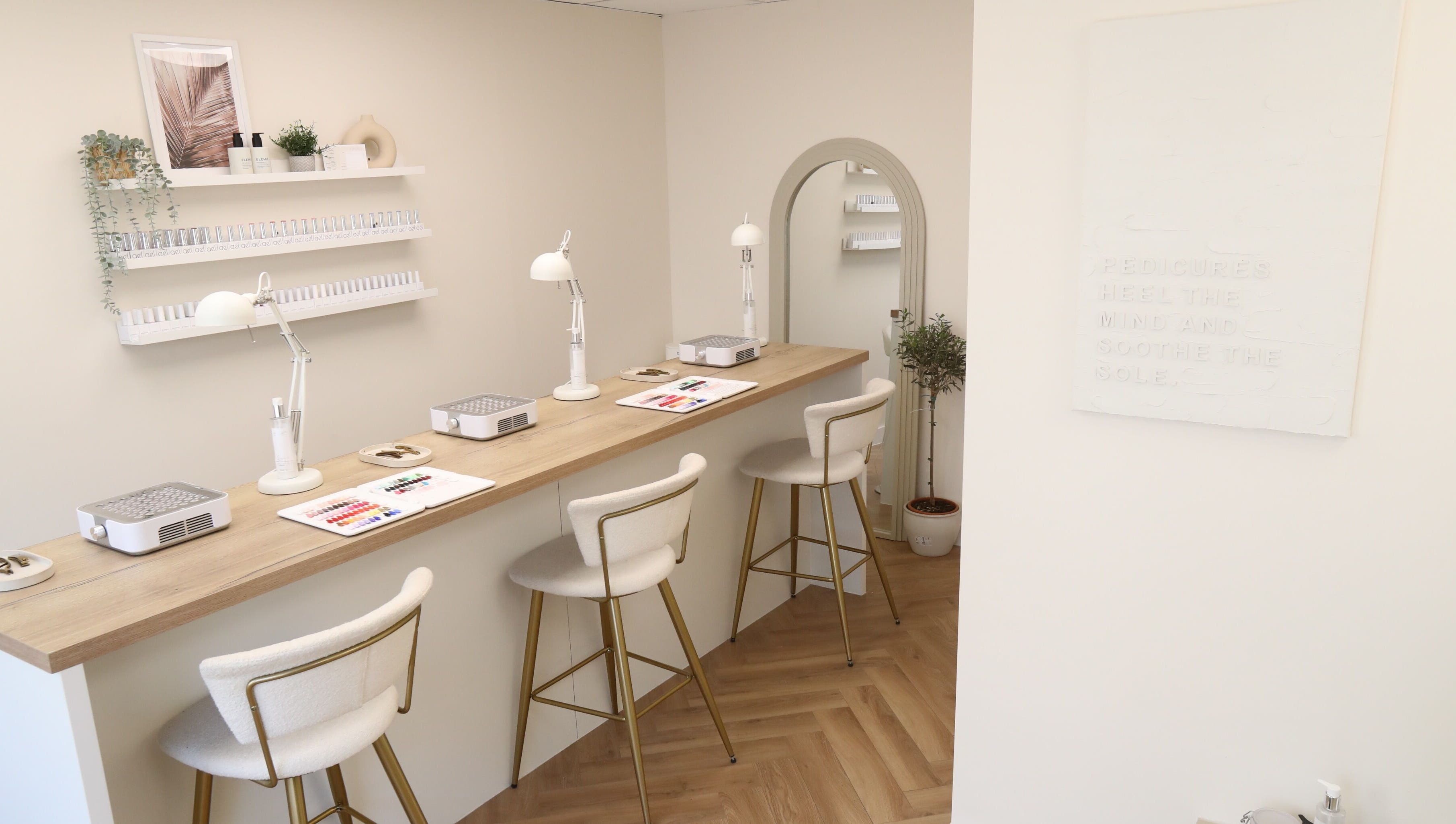 Elegant nail bar with plush chairs at Cure&Co., Chepstow, GB. Displays of nail polish and decor adorn the space.