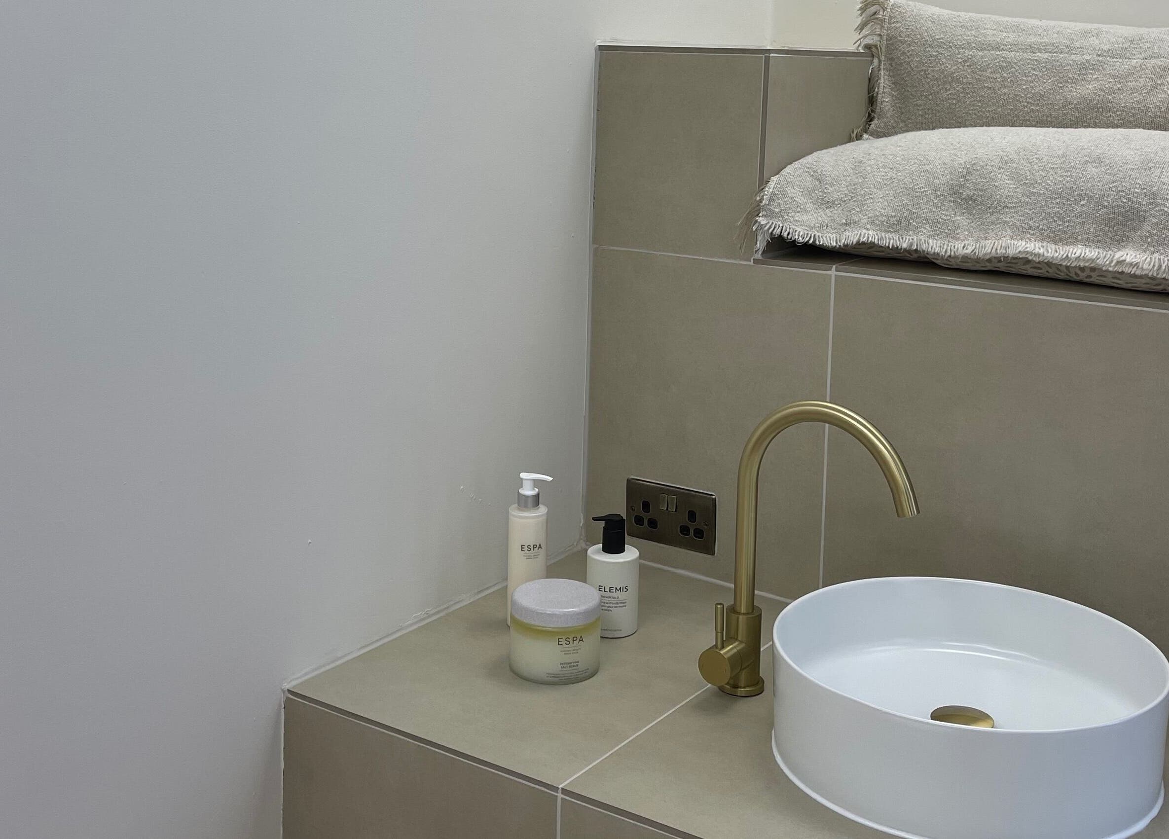 Luxurious spa sink with gold faucet at Cure&Co., Chepstow, GB, featuring Elemis and Espa products.