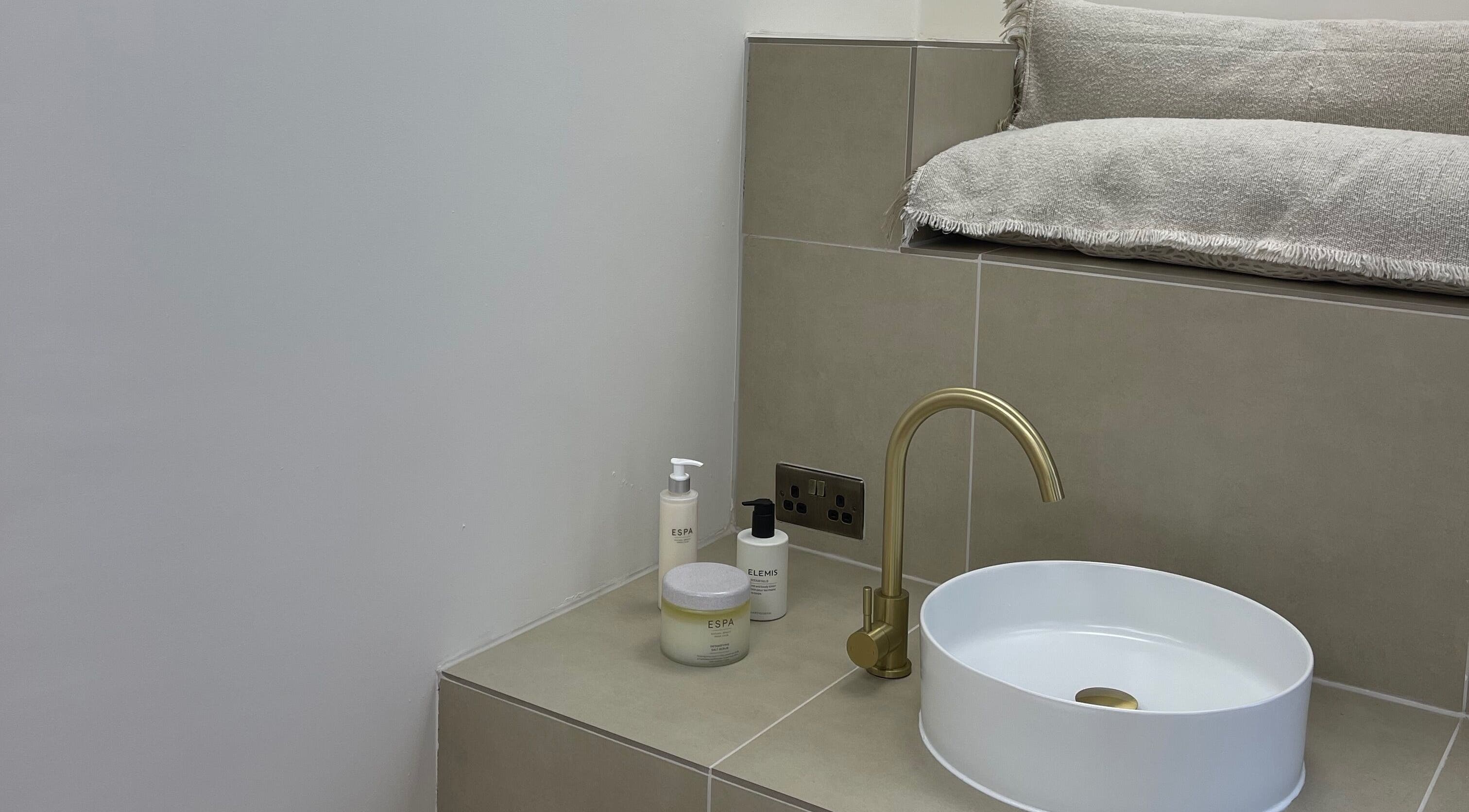 Luxurious spa sink with gold faucet at Cure&Co., Chepstow, GB, featuring Elemis and Espa products.