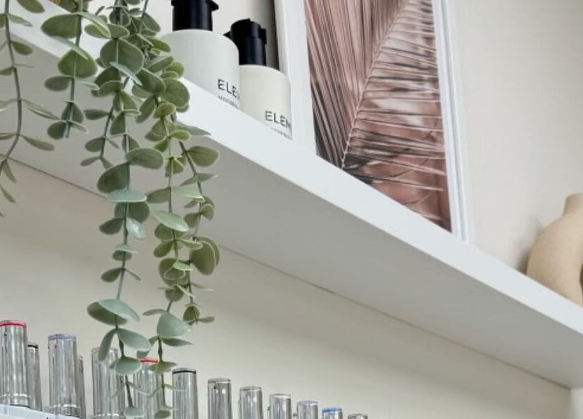 Elegant shelf with decor and products at Cure&Co., Chepstow, GB showcasing natural beauty elements.