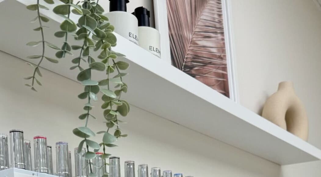 Elegant shelf with decor and products at Cure&Co., Chepstow, GB showcasing natural beauty elements.