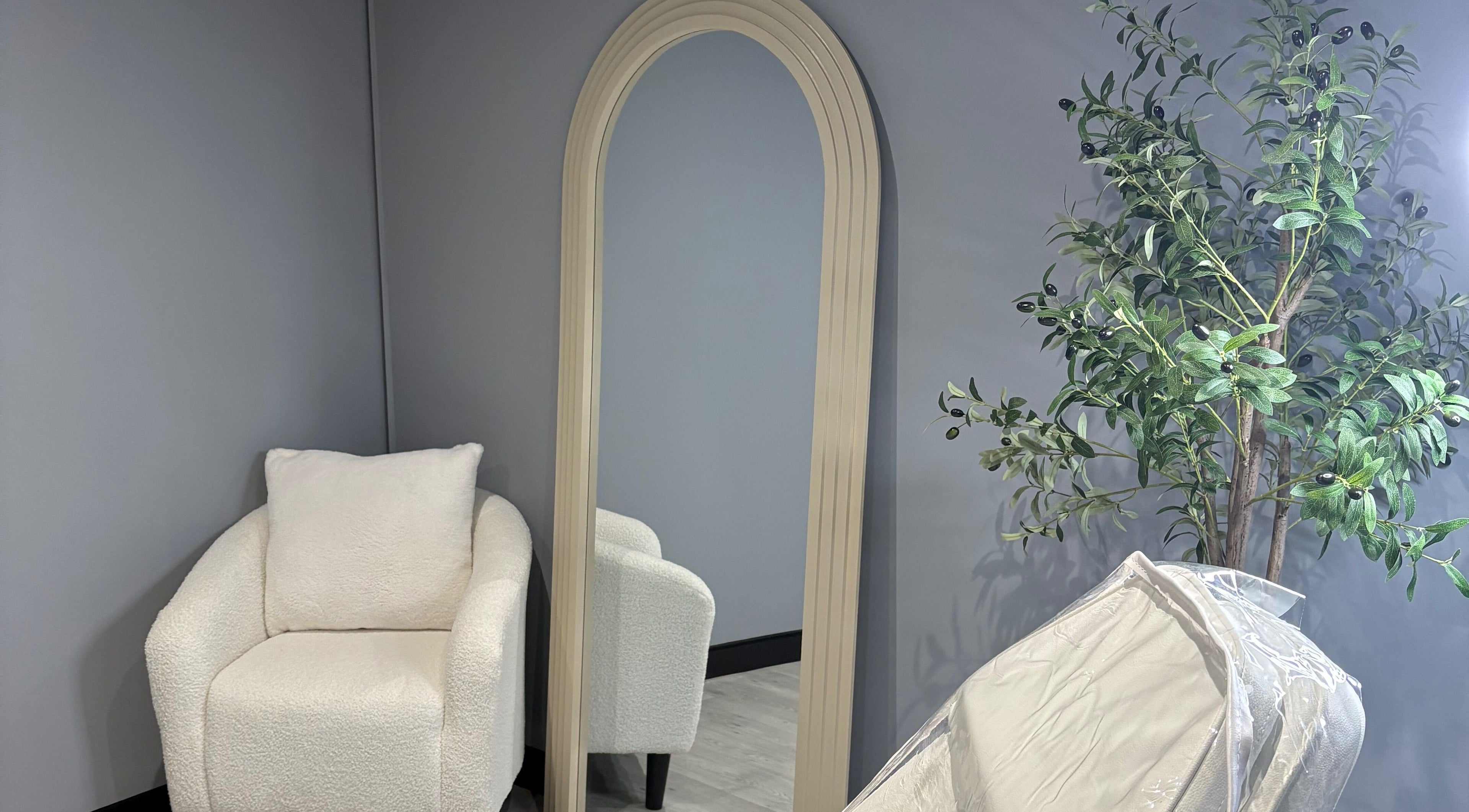 Elegant chair and mirror setup at All About Aesthetics, Fareham, England, GB, featuring soothing decor.