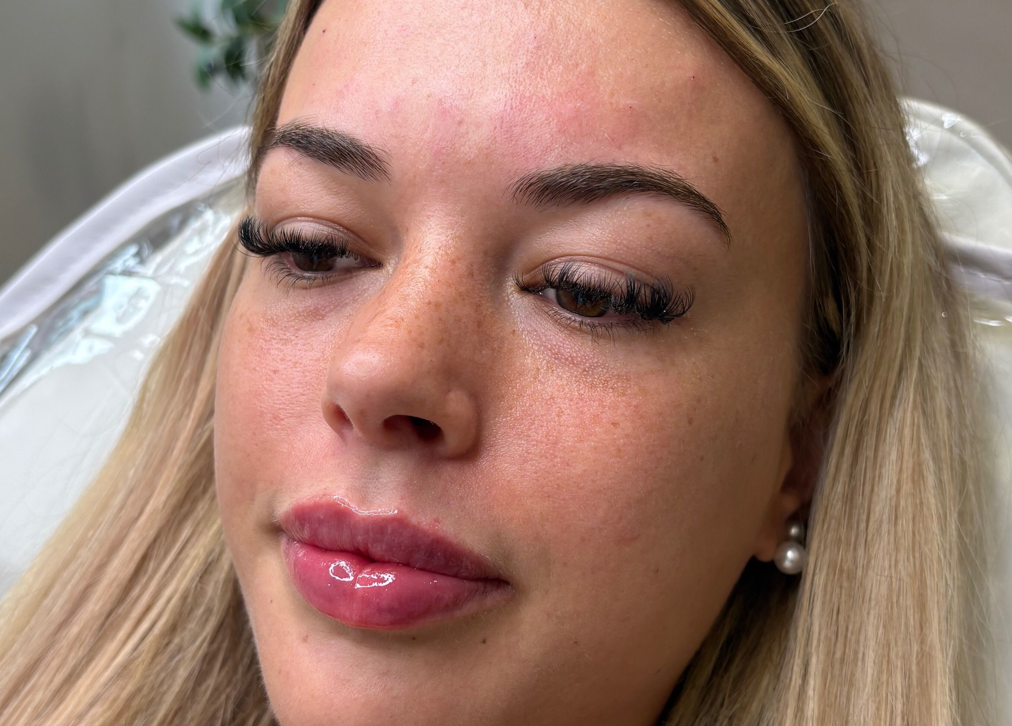 Close-up of a client with radiant skin and glossy lips at All About Aesthetics, Fareham, England, GB.