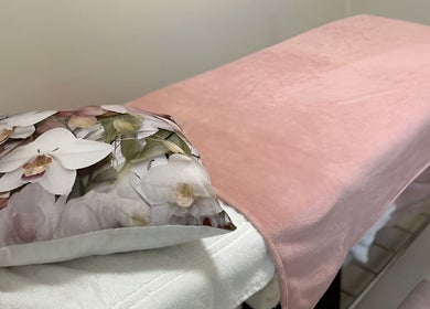 Relaxing massage table at Mademoiselle Hair and Beauty, Cape Town, Western Cape, ZA with floral cushion.