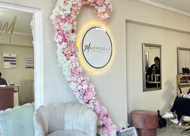 Elegant interior of Mademoiselle Hair and Beauty, Cape Town, Western Cape, ZA, featuring floral decor and salon seating.