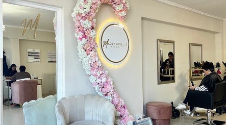 Chic interior of Mademoiselle Hair and Beauty in Cape Town, Western Cape, with floral decor and cozy seating.