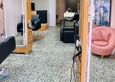Interior elegante de Yepes Hair Studio en Soacha, Cundinamarca, CO, con sillones negros y espejo amplio.