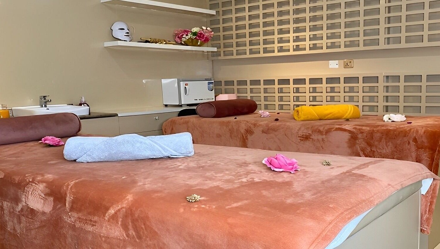 Luxurious spa beds at LIOCA ESTHETICS, SPA & SALON, Lagos, NG, adorned with flowers for a serene experience.