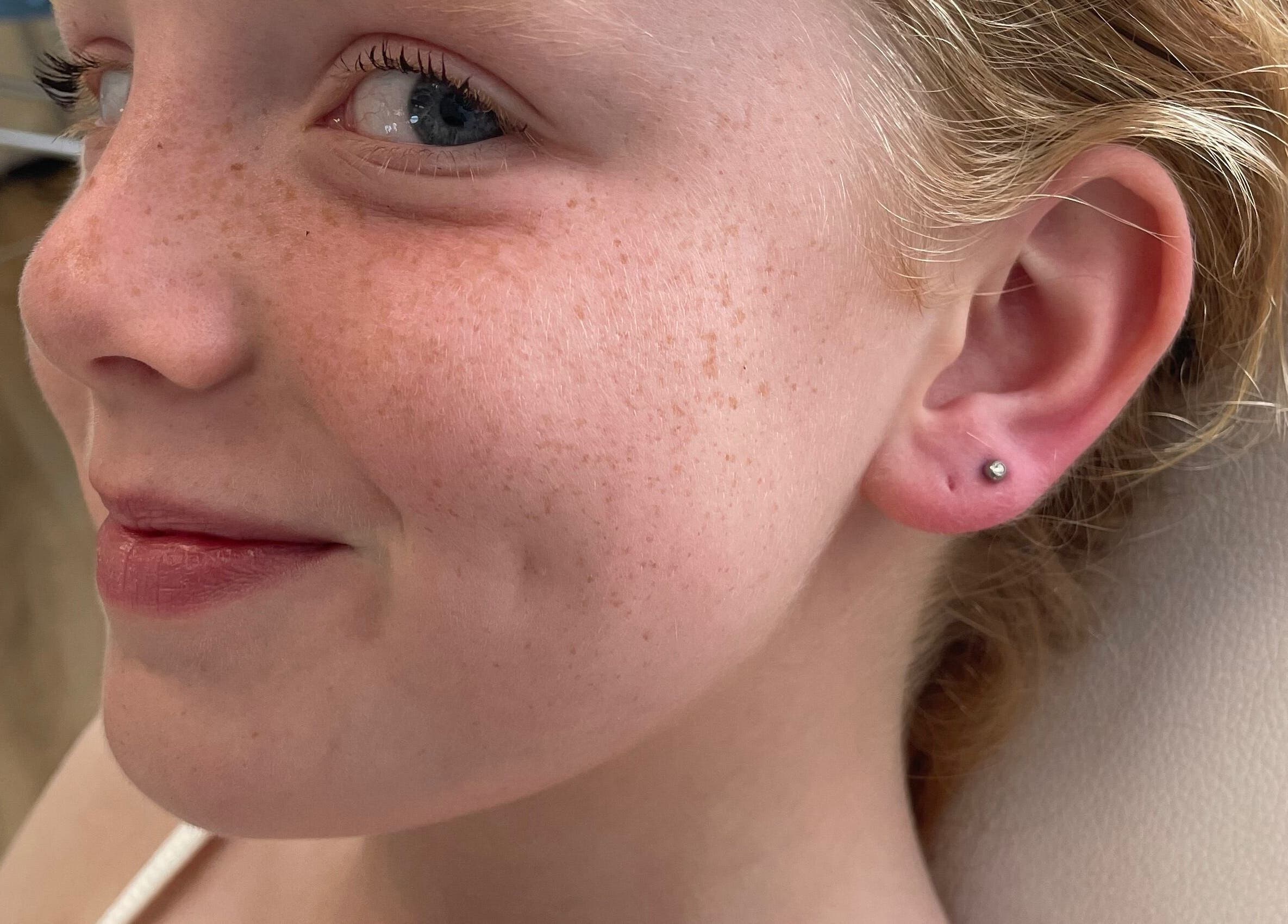 Child's ear with a new piercing at Rejuv by V, Newcastle, England, GB.