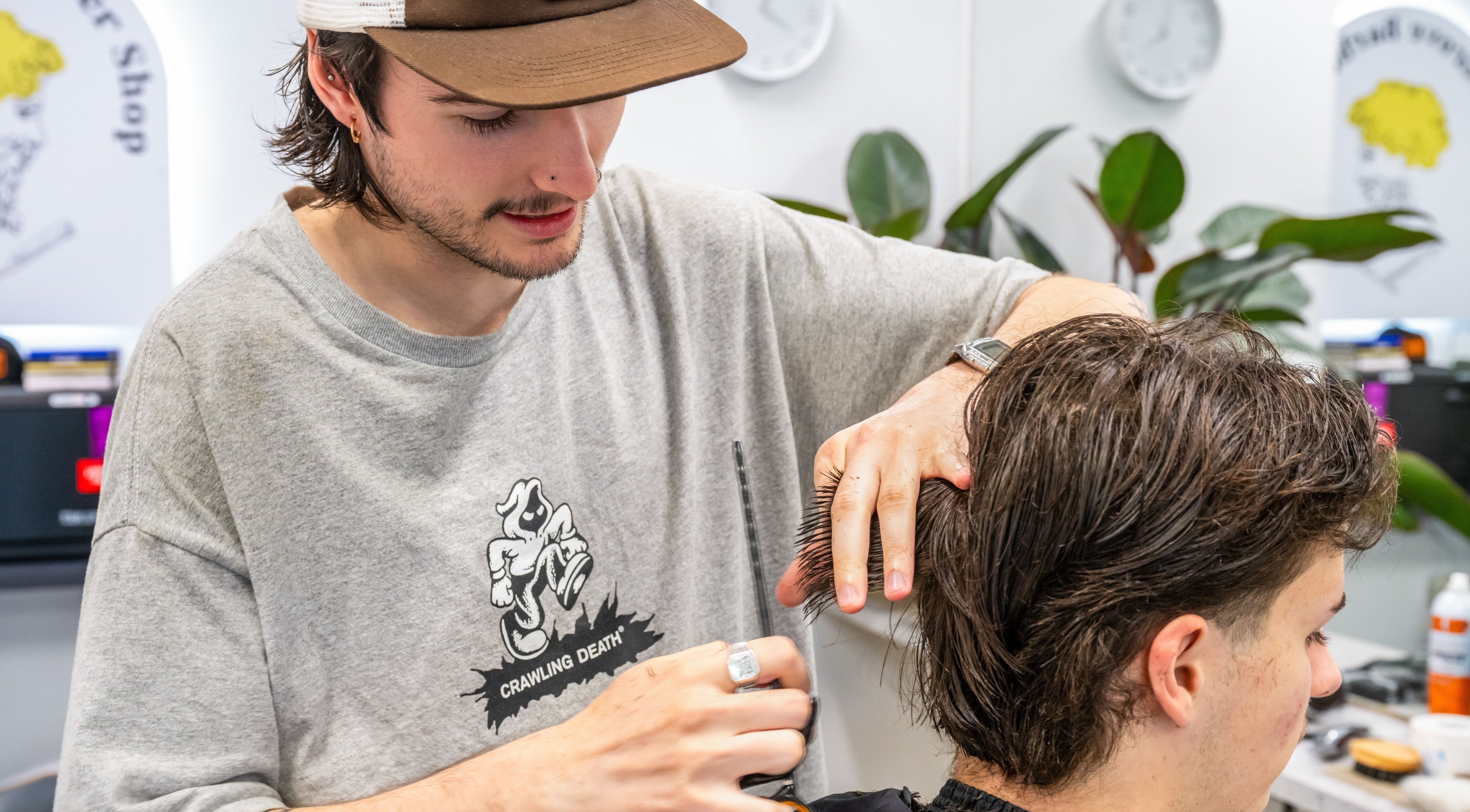 Barber styling hair at Ocean Grove Barbershop, Ocean Grove, VIC, AU. Modern cuts in a trendy setting.